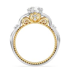 a yellow and white gold ring with an intricate design on the center, surrounded by diamonds