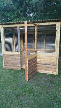 a small wooden structure with windows in the grass