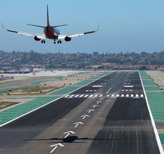 an airplane is taking off from the airport runway with it's landing gear down