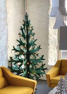 a living room with yellow chairs and a christmas tree