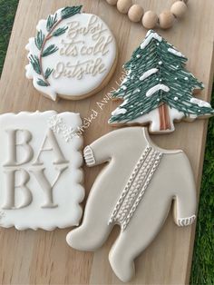 some cookies are laying on a board in the grass and one is decorated with icing