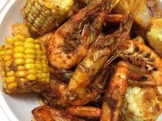 a white plate topped with shrimp and corn