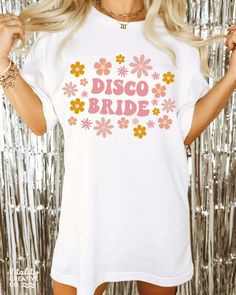 a woman wearing a white t - shirt that says bride with flowers on the front