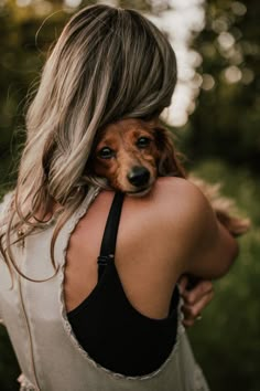 a woman holding a dog in her arms