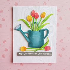 a handmade card with flowers in a watering can