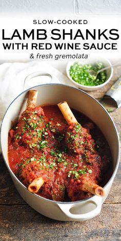 a pot filled with meat and sauce on top of a wooden table next to a bowl of peas