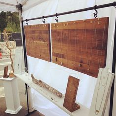 two wooden boards are on display under a white tent with chains hanging from it's sides