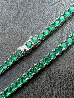 Gorgeous women's or mens 3mm tennis chains.
Solid 925 sterling silver.
Handmade
15-25ct man made green emerald...SO ICY THEY WILL BLIND YOU!
Man made &  look just like natural gemstones and cant tell difference apart without a microscope
Vivid green color
 
Never changes color! Why buy brass from others when you can get real solid silver with us!
LIFETIME GUARANTEE!

3mm thick
16-28" in length so you can wear as a choker or a longer chain!
 
21-33 grams de Silver Oval Tennis Necklace Gift, Green Oval Tennis Bracelet As Gift, Green Oval Tennis Bracelet For Gift, Green Cubic Zirconia Round Tennis Bracelet, Green Round Cubic Zirconia Tennis Bracelet, Green Cubic Zirconia Tennis Bracelet, Aaa Quality Round Emerald Jewelry, Emerald Tennis Bracelet Gift, Round Emerald Tennis Bracelet As Gift