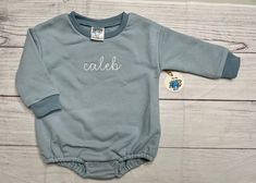 Sweatshirt Bubble romper name details: Everyone will love this adorable custom embroidered name sweatshirt bubble romper. Please enter name & thread colors in personalization field.  THREAD COLOR DEFAULTS & examples default colors on DinoSewBlue bubble thread for name is white like the caleb example. Names are in all lower case letters  Sweatshirt bubble Brand: DinoSewSuite branded sweatshirt bubble: Cotton/French terry blended Ribbed neckline  All fit true to size and are boutique quality shirt blanks made specifically for embroidery. Size up for a more oversized look. Every item is made by hand and handled with a lot of love and care. Each item can result in a bit different placement then the example pictures as each item is placed by hand by me. All sweatshirt bubbles have a soft backin Long Sleeve Cotton Bubble Romper For Loungewear, Long Sleeve Cotton Bubble Romper, Fitted Long Sleeve Cotton Bubble Romper, Customizable Long Sleeve Cotton Onesie, Casual Long Sleeve Bubble Romper For Loungewear, Personalized Cotton Onesie For Loungewear, Embroidered Name Sweatshirt, Bubble Brand, Sweatshirt Romper