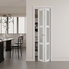 an empty kitchen with white walls and black counter tops is seen from the doorway to the dining room