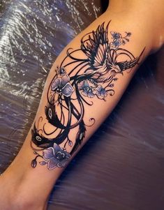 a woman's leg with tattoos on it and flowers in the middle of her arm