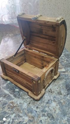 an open wooden box sitting on top of a counter next to a wall and floor