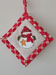 a red and white ornament with a snowman on it