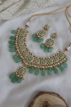 The green kundan necklace with mint fluorite stones is beautifully handcrafted by the artisans to represent the amalgamation of Indian craftsmanship and modern designs to bejewel your neckline. The bridal necklace with matching kundan earrings celebrates the heritage of Indian jewelry. Embedded with high-grade kundan and hand carved stones, the necklace set is an ode to the beautiful bride as she prepares to embark on her new chapter of life.  Necklace Closure - Adjustable Dori Earrings Closure Green Indian Necklace, Mint Green Indian Jewellery, Green Cutdana Jewelry For Celebration, Festive Kundan Emerald Gemstone Necklace, Green Kundan Emerald Necklace For Gift, Festive Emerald Kundan Necklace With Gemstones, Green Kundan Temple Necklace For Gift, Green Emerald Kundan Necklace With Gemstones, Traditional Handmade Emerald Necklaces