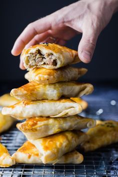 a stack of food on top of a metal rack next to a person's hand