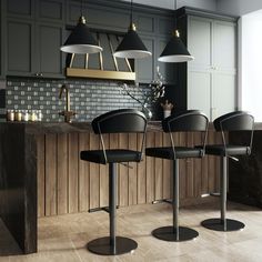 three black chairs sitting in front of a counter top with lights hanging above it and an island behind them