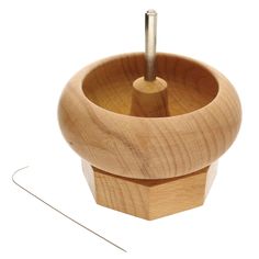 a wooden cup with two needles in it