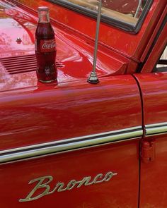 an old red car with the word bronco on it