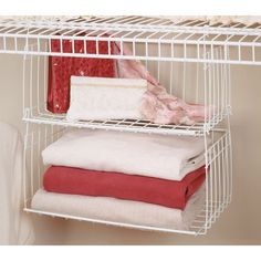 a white shelf with towels and blankets on it