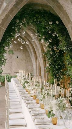 the table is set with white flowers and candles for an elegant wedding reception in italy