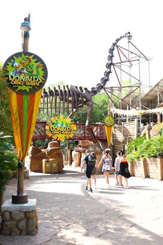 people are walking through an amusement park