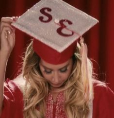 a woman wearing a red graduation cap and gown