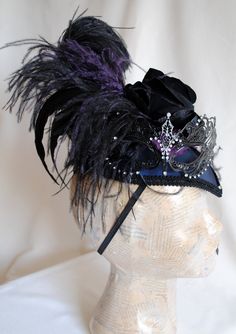 "This unique gothic-victorian masquerade headpiece was inspired by the luxurious Venice Carnival head-dresses. Created in a combination of midnight blue, black and purple. The teardrop base is covered with wonderful two-toned blue and black taffeta. I've used a gorgeous metal \"lace\" mask with rhinestones as the focal point. A glorious bouquet of flowers and feathers create a textured and one of a kind piece. A fluffy black ostrich, along with long iridescent rooster feathers and accents of pur Steampunk Masquerade Mask For Carnival Cosplay, Steampunk Masquerade Mask For Carnival, Gothic Masks And Prosthetics For Costume Party, Steampunk Mask Costume Accessories, Adjustable Carnival Headpieces For Costume Party, Gothic Masks And Prosthetics For Halloween Theater, Adjustable Carnival Costume Party Headpieces, Fantasy Eye Mask For Costume Masquerade, Fantasy Eye Mask For Masquerade Costume