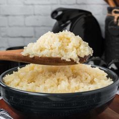 rice in a black bowl with a wooden spoon