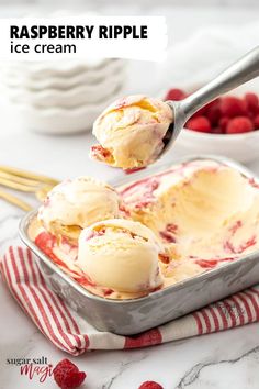 two scoops of raspberry ripple ice cream in a metal pan with strawberries on the side