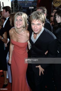 two people standing next to each other on a red carpet at an awards ceremony in front of