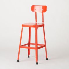 an orange plastic chair with wheels on the back and seat is shown in front of a white background