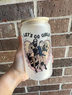 a person holding up a plastic cup with the words let's go girls on it