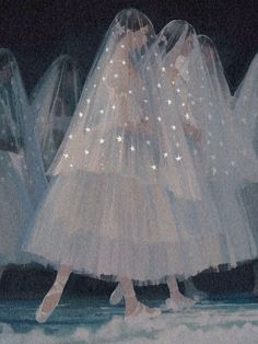 a group of women in white dresses and veils walking on the runway at night