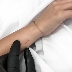 a woman's arm with the word love written on it, and a hand in black gloves