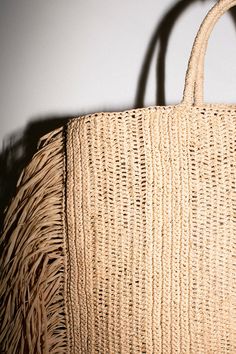 Raffina tote with woven handles, and 12" draped fringe at sides. Tote measures 14.5" wide (without fringe), 16" tall and 4" in depth. Handcrafted in France. Elegant Summer Bags With Fringe, Rectangular Natural Shoulder Bag With Fringe, Chic Straw Bag With Fringe, Chic Natural Color Bags With Fringe, Natural Color Rectangular Bags With Fringe, Natural Fringe Rectangular Shoulder Bag, Chic Natural Straw Bag With Fringe, Natural Shoulder Bag With Tassels For Shopping, Shopping Fringe Straw Tote Bag