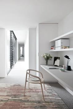 a chair sitting on top of a rug in a living room next to a desk