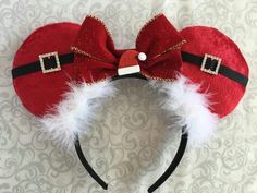 a red mickey mouse ears headband with white and black fur on top of it