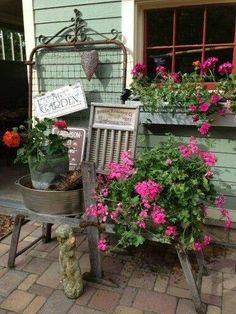 an old chair with potted flowers on the back is sitting in front of a building