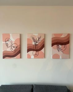 three paintings hang on the wall above a couch