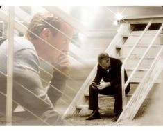 a man sitting on top of a wooden bench next to a stair case