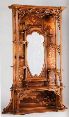 an ornate wooden cabinet with mirror in it's center and carvings on the front