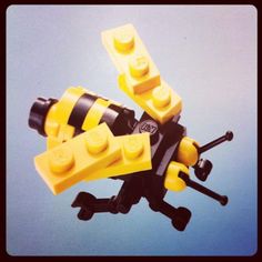 two legos that are made to look like bees flying through the air with their hands together