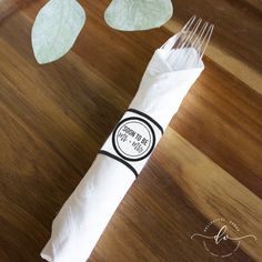 a piece of white paper sitting on top of a wooden table next to a fork