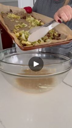 a person cutting up food in a bowl with a large knife on top of it