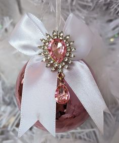 a pink ornament hanging from a christmas tree