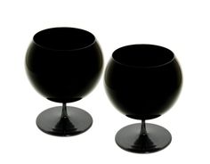 two black goblets sitting side by side on a white background, one is empty