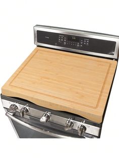 a wooden cutting board sitting on top of an oven