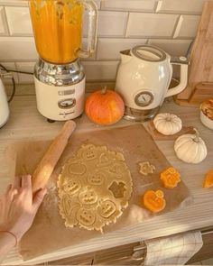 a woman is making pumpkin pies in the kitchen with an orange juice blender