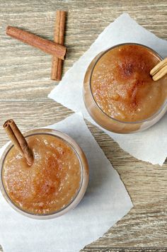 two glasses filled with cinnamon drink on top of paper