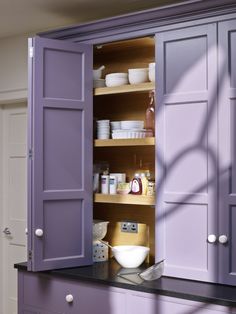 an open cabinet with dishes and bowls in it